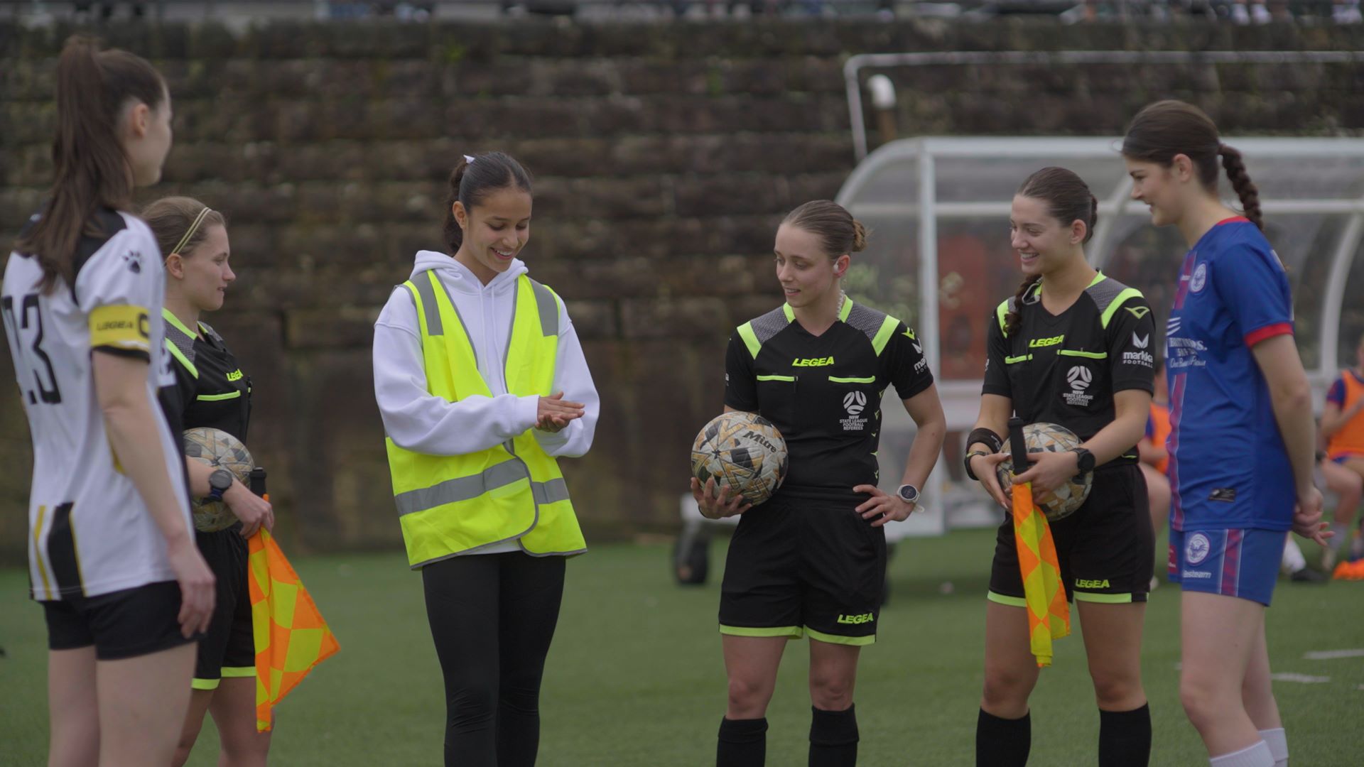 Talia Younis tosses a coin before a match, alongside referees and team captains